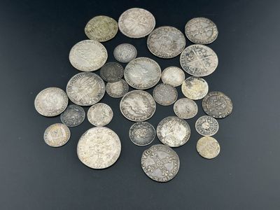 quelques très vieilles pièces d'argent posées sur une surface noire