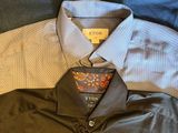 three men ' s shirts are laid out on a wooden surface