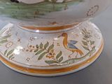 a white bowl with a bird on it on a table