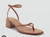 a pair of women ' s tan leather sandals with ankle straps