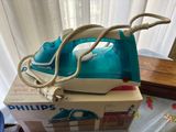 a blue and white steam iron sitting on top of a box