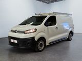 La camionnette blanche est garée dans la grande salle du bâtiment.