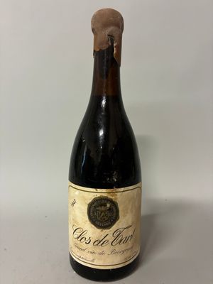 an old bottle of wine sitting on top of a table