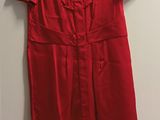 une robe rouge suspendue à un cintre dans une pièce