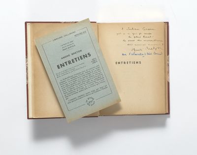 un livre ouvert posé sur une table à côté d'une feuille de papier