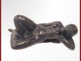une statue représentant une femme allongée sur un oreiller