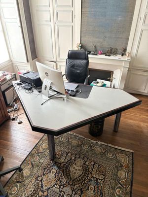 un bureau sur lequel sont posés deux ordinateurs portables, au milieu d'une pièce