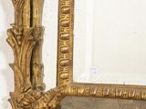 a mirror with a gold frame hanging on the wall