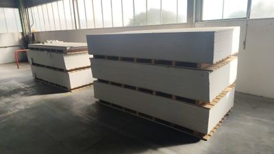 deux grandes piles de carton blanc empilées l'une sur l'autre dans un entrepôt