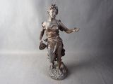 bronze statue of a woman holding a basket of flowers on a rock