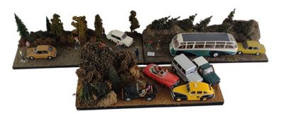 trois voitures miniatures et un bus exposés sur une table