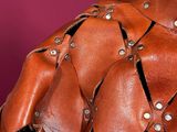 a close up of a brown leather jacket on a mannequin