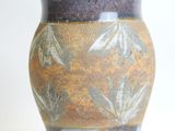a close up of a vase on a white surface