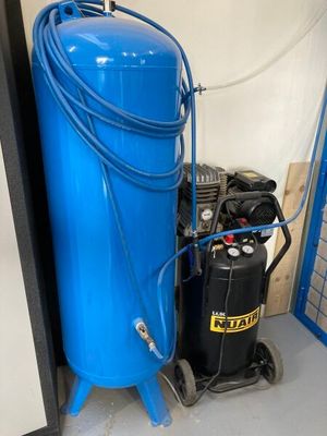 un compresseur d'air bleu posé à côté d'un réservoir bleu