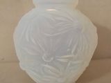 un vase en verre blanc orné d'un motif floral