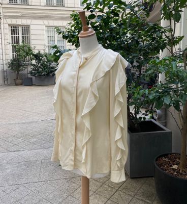 a mannequin in front of a building with a tree in the background