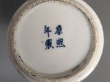 a close up of a white vase with blue writing on it