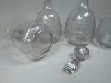 three glass bottles and a salt shaker on a table