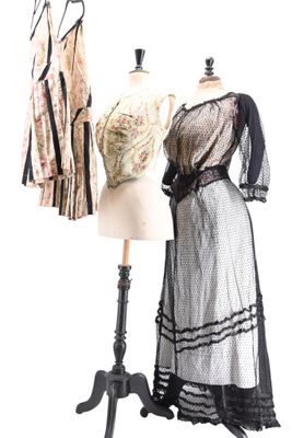 two dresses on a mannequin stand next to each other