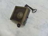 a small metal box with a key on a marble table