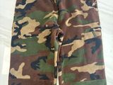 un gros plan d'un pantalon de camouflage posé sur une surface blanche