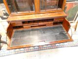 a wooden cabinet with glass doors on top of it
