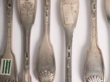 a lot of silver spoons and forks on the table