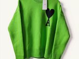 neon green sweater with black heart on the chest