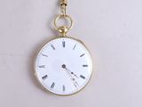 a gold pocket watch with roman numerals on it