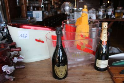 une bouteille de champagne et deux bouteilles de vin posées sur une table