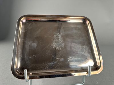 a silver tray on a metal stand on a table