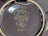 a close up of a black and gold plate with a logo on it