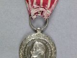 une médaille d'argent entourée d'un ruban rouge et une médaille d'argent entourée d'un ruban rouge