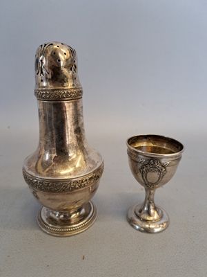 un vase en argent et une coupe en argent posés sur une table