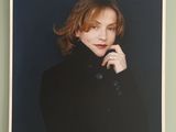 an old photo of a woman in a black coat posing for a picture