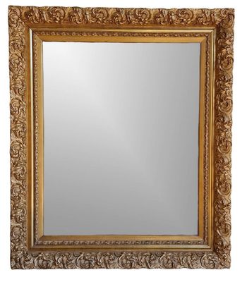 un miroir à cadre doré, orné d'un motif décoratif sur fond blanc