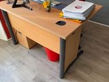 a desk with a computer and a red chair in the corner