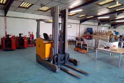a forklift in a warehouse with lots of boxes on the floor