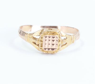 a close up of a gold ring with a pink stone in the center