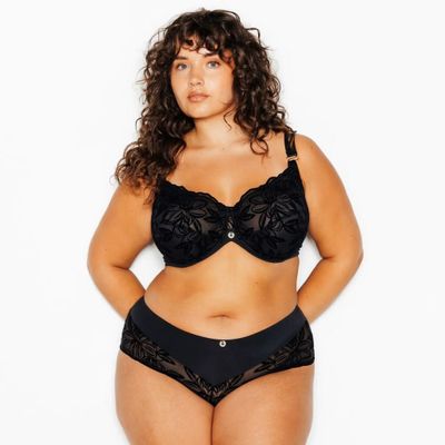 une femme en soutien-gorge et culotte noirs posant pour une photo