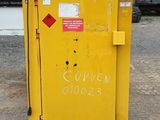 a yellow box with a sign on it in front of a building