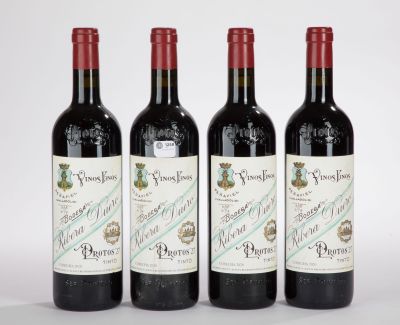 trois bouteilles de vin sont alignées sur une surface blanche