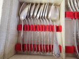 many spoons and forks in a box with red handles