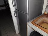 une petite cuisine équipée d'un évier et d'un réfrigérateur