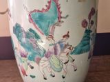 a large vase with a painting on it sitting on a table