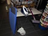 a blue and black iron on a table in a store