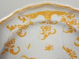 a yellow and white plate with a design on it