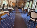 many tables and chairs in this restaurant with blue carpet