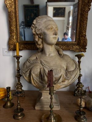 a bust of a woman sitting on a table next to a mirror