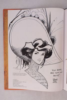 un livre ouvert sur lequel figure le dessin d'une femme portant un chapeau